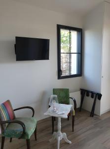 a living room with two chairs and a table and a tv at Chambres D'hôtes - Noirmoutier in LʼÉpine