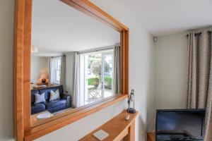 a mirror in a living room with a couch and a tv at 3 Combehaven in Salcombe