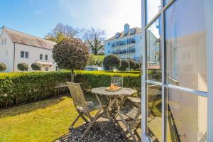 a table and chairs on a patio with a view of a building at 3 Combehaven in Salcombe