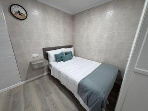 a small bedroom with a bed and a clock on the wall at Rincon del puerto I in A Guarda