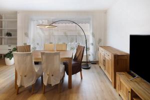 a dining room with a table and chairs and a television at Happy Place in Ilmenau