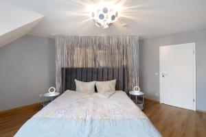 a bedroom with a large bed and a chandelier at Happy Place in Ilmenau