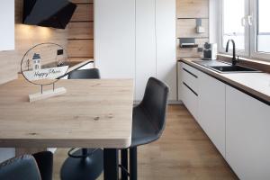 a kitchen with a wooden table and black chairs at Happy Place in Ilmenau +15 photos