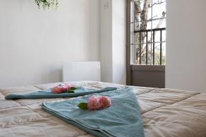 a bed with two towels and flowers on it at Petit gîte bleu jusqu'à 4 personnes in Huillé