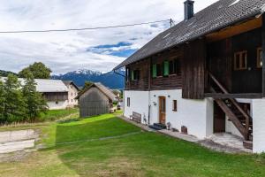 a farmhouse with a barn and mountains in the background at Penthouse im Bauernhaus in Kötschach