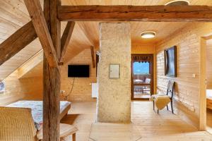 a bedroom in a log cabin with a bed and a tv at Penthouse im Bauernhaus in Kötschach