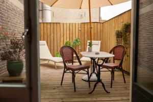 a patio with a table and chairs and an umbrella at Hotel By Atelier in Nijmegen