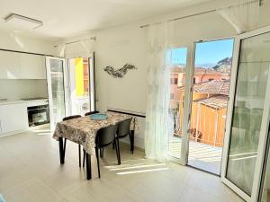 a dining room with a table and chairs and a balcony at Appartamento Mavi in Porto Azzurro