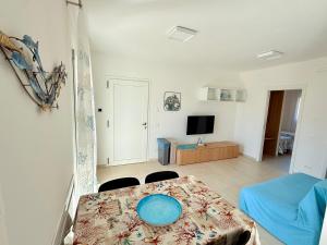 a living room with a table with a blue plate on it at Appartamento Mavi in Porto Azzurro