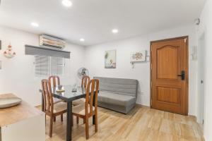 a kitchen and dining room with a table and a couch at Encanto Costero in Ayamonte