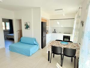 a kitchen and living room with a table and chairs at Appartamento Mavi in Porto Azzurro