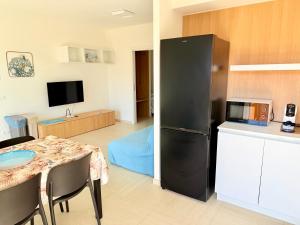 a kitchen with a table and a refrigerator in a room at Appartamento Mavi in Porto Azzurro +12 photos