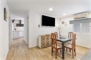 a dining room with a table and chairs and a television at Encanto Costero in Ayamonte