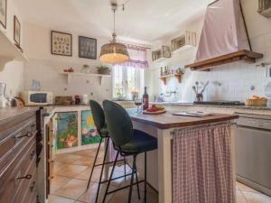 a kitchen with two bar stools at a kitchen island at Il Giardino Etrusco Bolsena in Bolsena