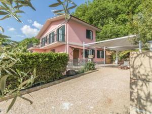 a pink house with a patio and trees at Il Giardino Etrusco Bolsena in Bolsena