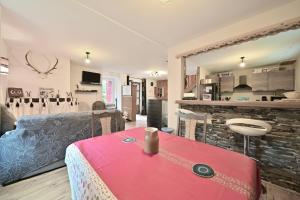 a living room with a red table and a couch at Pays De L'ours - Pyrénées in Melles +12 photos