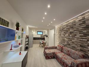 a living room with a couch and a brick wall at Casa Mia Holiday House in Pianillo