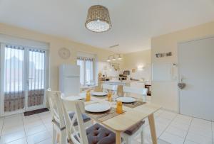a kitchen and dining room with a table and chairs at Grain de sable in Saint-Benoît-des-Ondes +18 photos