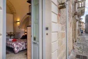 a door to a bedroom with a bed in a room at Monolocale Delux Alithia in Muro Leccese