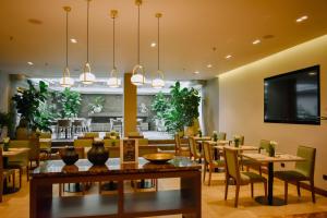 a dining room with tables and chairs and a restaurant at Hotel Estelar Calle 100 in Bogotá