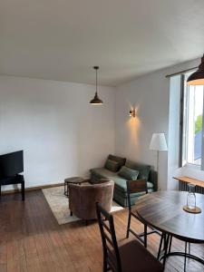 a living room with a couch and a table at Cocon urbain avec jardin - appartement proche hôpital in Angers