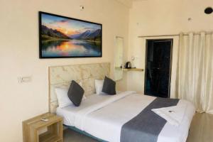 a bedroom with a bed with a painting on the wall at Hotel The regal inn in Varanasi +12 photos