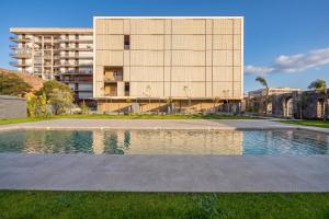 a building with a swimming pool in front of a building at Rotolo Roof 21 5C in Catania