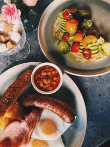 a table with two plates of food with sausage and beans at Beds at 46, Cowes in Cowes