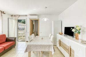 a white living room with a table and a couch at San Enrique in L'Escala
