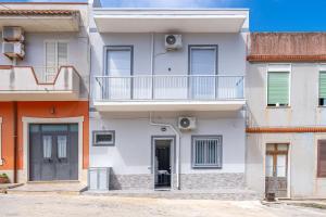an apartment building with a balcony and a door at Le Quattro Perle Apartments in Pachino
