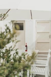a bottle of wine sitting on a bench in front of a door at House Avlomonas in Livadi