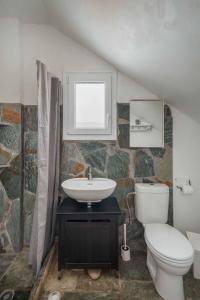 a bathroom with a sink and a toilet and a window at House Avlomonas in Livadi +12 photos