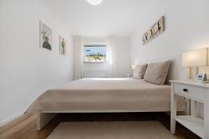 a white bedroom with a bed and a window at Ferienwohnung Auszeit in Calw