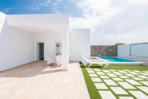 a white house with a swimming pool and a patio at Casa El Palmar 2 in Vejer de la Frontera