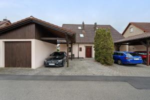 two cars parked in a parking lot in front of a house at Ferienwohnung Auszeit in Calw