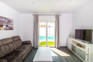 a living room with a couch and a television at Casa El Palmar 2 in Vejer de la Frontera