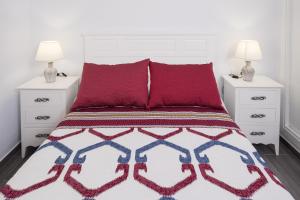 a bedroom with a bed with red pillows and two night stands at Casa El Palmar 2 in Vejer de la Frontera +17 photos