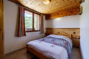 a bedroom with a bed in a room with a window at Primevère in Valloire
