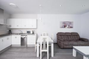 a kitchen and living room with a table and a couch at Casa El Palmar 2 in Vejer de la Frontera