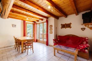 a living room with a red couch and a table at Primevère in Valloire