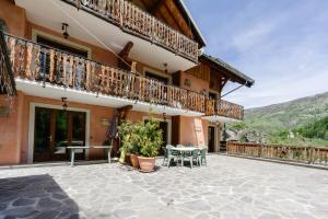 an outdoor patio of a house with a table and chairs at Primevère in Valloire