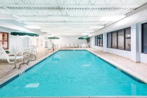a swimming pool with blue water in a building at Wingate by Wyndham Erie in Erie