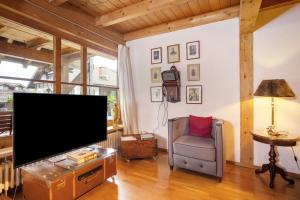 a living room with a flat screen tv and a chair at Ferienhaus Chalet Montfort in Sonthofen