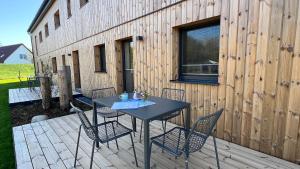 a table and chairs on a deck with a building at Strandnahe Fewo 1 in Dierhagen