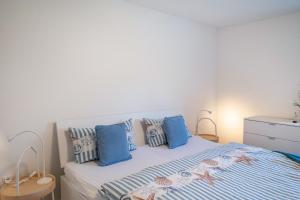 a bedroom with a bed with blue and white pillows at Strandnahe Fewo 1 in Dierhagen