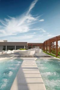 a swimming pool in front of a building at Apec Beach Luxury Mũi Né in Mui Ne