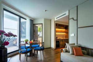 a living room with a couch and a table with chairs at Apec Beach Luxury Mũi Né in Mui Ne