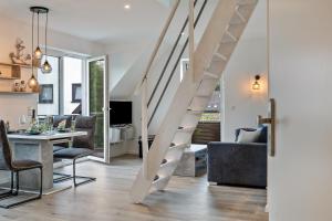 a living room and dining room with a staircase in a house at Ostseerauschen in Hohwacht