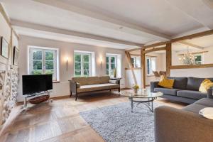 a living room with a couch and a tv at Hof Hohe Eichen in Göhrde