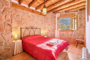 a bedroom with a red bed in a stone wall at Cortijo El Plantío Castril in Castril +78 photos